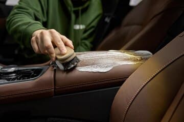 Close-up of hand touching perfectly cleaned and conditioned leather steering wheel